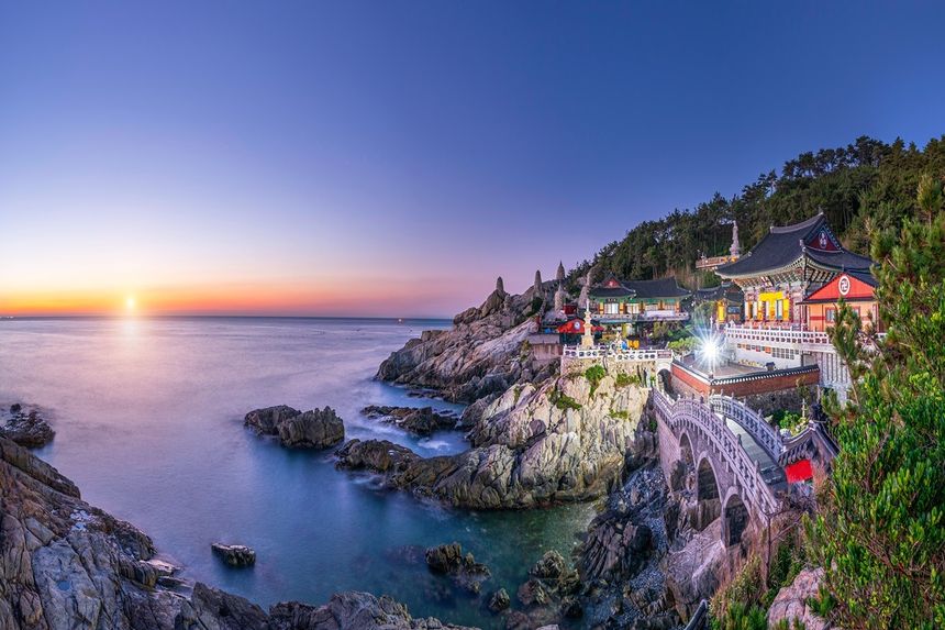 The seaside temple of Haedong Yonggungsa on its rocky headland above the water at sunrise.